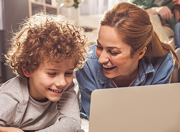 Frau und Junge sehen etwas auf dem Laptop an