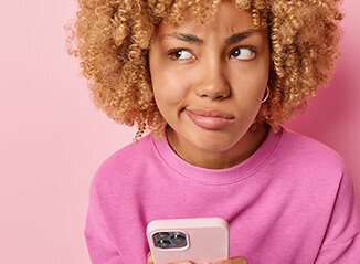 Zum Beitrag: Fakt oder Fake? Zu sehen: Skeptisches Mädchen mit Smartphone