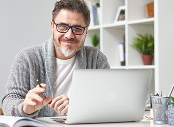 Mann sitzt vor Laptop