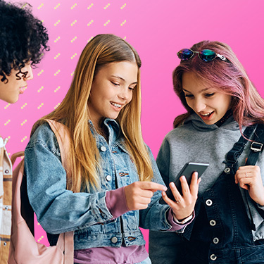 Drei Jugendliche betrachten gemeinsam ein Smartphone und lächeln, vor pinkem Hintergrund.