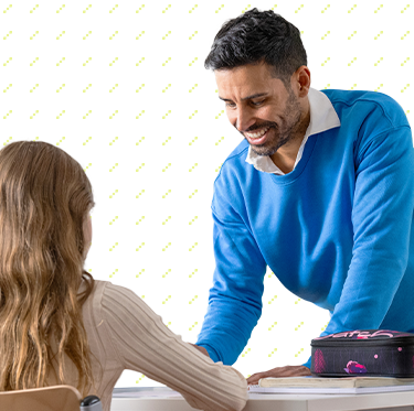 Lehrer erklärt einer Schülerin etwas.